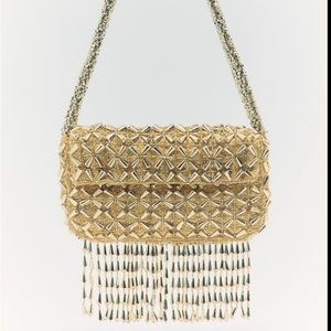 Shoulder bag with beading and fringe. Magnetic closure at flap.